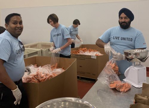 Ingrid Estrada (second from left) volunteering side-by-side with other Keysight employees bagging carrots for distribution through the Redwood Empire Food Bank.